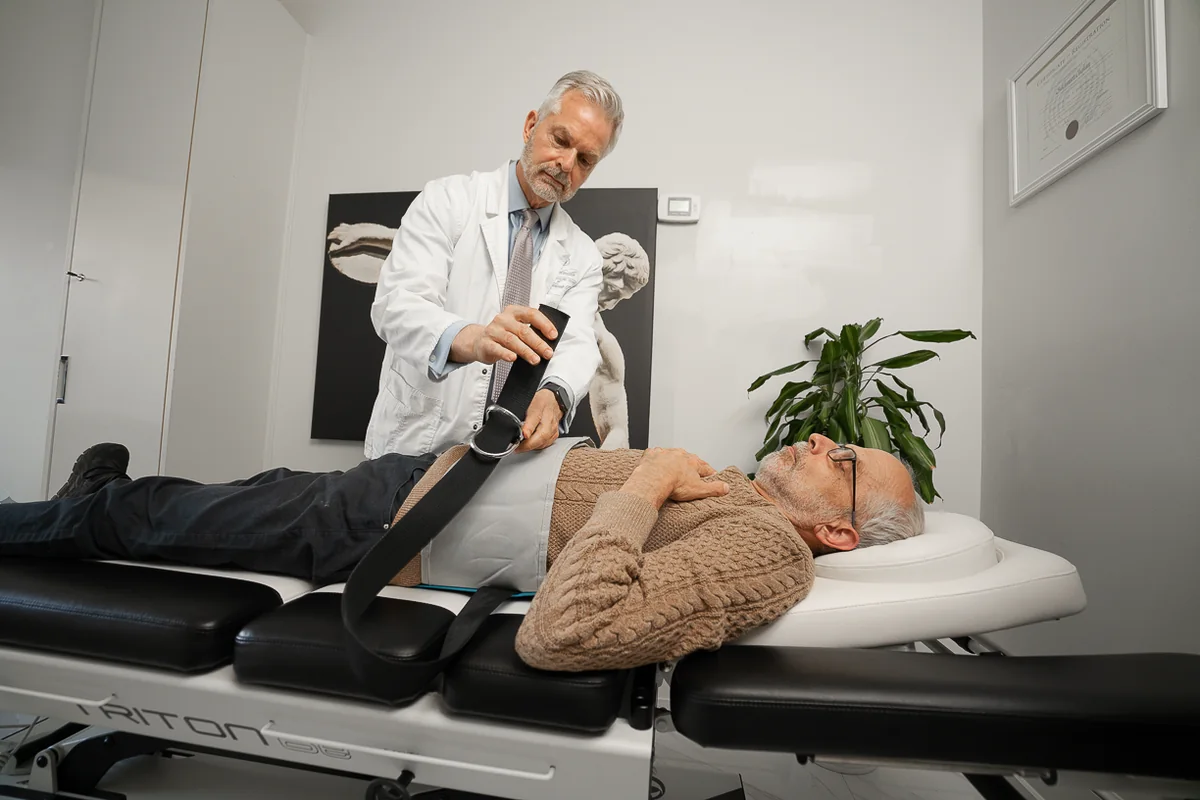 The decompression harness being tightened on a patient at Yorkville Sports Medicine